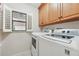 Functional laundry room with a side-by-side washer and dryer and storage cabinets at 3505 Tarpon Woods Blvd # K409, Palm Harbor, FL 34685