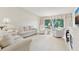 Bright living room with white furnishings, large windows, and a cozy fireplace at 3505 Tarpon Woods Blvd # K409, Palm Harbor, FL 34685