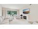 Bright living room with white furnishings, large windows, and a cozy fireplace at 3505 Tarpon Woods Blvd # K409, Palm Harbor, FL 34685