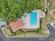 Aerial view of a pool and jacuzzi surrounded by trees and lounge chairs at 3505 Tarpon Woods Blvd # K409, Palm Harbor, FL 34685