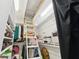 Bright walk-in closet with custom shelving, hanging racks, and a pull-down ladder to an attic space at 3505 Tarpon Woods Blvd # K409, Palm Harbor, FL 34685