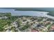 An aerial view shows a neighborhood near a large lake and covered in trees at 3956 Tarpon Pointe Cir, Palm Harbor, FL 34684