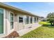 Backyard view of house, door to Florida room, windows, grass and mulch at 3956 Tarpon Pointe Cir, Palm Harbor, FL 34684