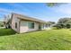 Backyard view of house, showing grass, stucco, windows, and roof at 3956 Tarpon Pointe Cir, Palm Harbor, FL 34684