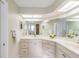 Bright bathroom featuring updated vanity, countertops, mirrors and tile floors at 3956 Tarpon Pointe Cir, Palm Harbor, FL 34684