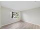 This bedroom features neutral walls, wood-look flooring and a bright window at 3956 Tarpon Pointe Cir, Palm Harbor, FL 34684