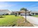 Single-story home with a well-manicured lawn, mature landscaping, and an attached two-car garage at 3956 Tarpon Pointe Cir, Palm Harbor, FL 34684
