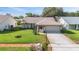 Charming single-story home boasting a well-kept lawn, mature palm trees, and a two-car garage at 3956 Tarpon Pointe Cir, Palm Harbor, FL 34684