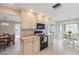 Modern kitchen with cream cabinets, black oven, and eat-in breakfast nook with views to the exterior at 3956 Tarpon Pointe Cir, Palm Harbor, FL 34684
