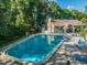 Beautiful community pool and clubhouse with lounge chairs for residents at 3956 Tarpon Pointe Cir, Palm Harbor, FL 34684
