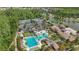 Aerial view features a community pool, tennis courts, clubhouse, lake and lush landscaping at 4195 Barletta Ct, Wesley Chapel, FL 33543