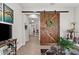 Stylish hallway featuring a rustic barn door, decorative plants, and warm, neutral tones at 4195 Barletta Ct, Wesley Chapel, FL 33543