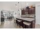 Elegant kitchen featuring dark wood cabinets, granite countertops, an island with seating, and stainless steel appliances at 4195 Barletta Ct, Wesley Chapel, FL 33543