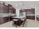 Well-equipped kitchen with dark cabinets, stainless steel appliances, a center island with seating, and stylish backsplash at 4195 Barletta Ct, Wesley Chapel, FL 33543
