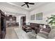 Cozy living room adjacent to kitchen, featuring a comfortable sofa, patterned rug, and a ceiling fan at 4195 Barletta Ct, Wesley Chapel, FL 33543