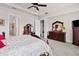 Bright main bedroom boasts a tray ceiling, two large windows, wood furniture and en-suite bath at 4195 Barletta Ct, Wesley Chapel, FL 33543
