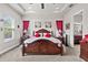 Elegant main bedroom featuring tray ceiling, large windows, red accents, and ample natural light at 4195 Barletta Ct, Wesley Chapel, FL 33543