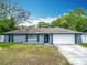 Charming single-story home with a blue exterior, attached garage, and front yard at 4435 Lamson Ave, Spring Hill, FL 34608