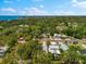Aerial view of a tree-filled neighborhood with a distant ocean view at 475 Crystal Beach, Crystal Beach, FL 34681
