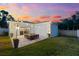 Backyard patio with outdoor seating, lush lawn, and warm string lighting against a twilight sky at 475 Crystal Beach, Crystal Beach, FL 34681