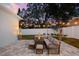 Landscaped backyard patio with outdoor seating, elegant planters and atmospheric string lights at 475 Crystal Beach, Crystal Beach, FL 34681
