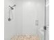 This is a walk-in shower with sleek glass doors, subway tile walls, and a pebble floor at 475 Crystal Beach, Crystal Beach, FL 34681