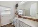Bright bathroom featuring a decorative mirror, and a white vanity complemented by stylish white cabinets at 4915 Fort Peck Rd, New Port Richey, FL 34655