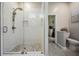 Modern bathroom with a glass-enclosed shower, white tile, and neutral decor, complemented by wood-look floors at 4915 Fort Peck Rd, New Port Richey, FL 34655