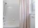 Bathroom featuring a white shower with a showerhead, a curtain, and tiled walls for easy cleaning at 4915 Fort Peck Rd, New Port Richey, FL 34655