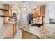 Functional kitchen with granite countertops, stainless steel appliances, and wood cabinets at 4915 Fort Peck Rd, New Port Richey, FL 34655