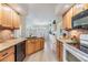 Bright kitchen boasts an island, granite countertops, stainless appliances, and ample wooden cabinet space at 4915 Fort Peck Rd, New Port Richey, FL 34655