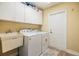 Well-equipped laundry room features a sink, washer, dryer, and ample storage cabinets at 4915 Fort Peck Rd, New Port Richey, FL 34655