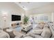 Comfortable living room with a large TV, a modern coffee table, and views to the desk area at 4915 Fort Peck Rd, New Port Richey, FL 34655