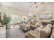 Inviting living room with a sectional sofa, wood floors, and seamless flow to the desk area at 4915 Fort Peck Rd, New Port Richey, FL 34655