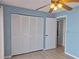 Cozy bedroom with a ceiling fan, closet, and light blue walls at 5404 Springwood Blvd # 5404, Pinellas Park, FL 33782