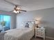 Cozy bedroom features a white bed, a nightstand, and a large window for ample light at 5404 Springwood Blvd # 5404, Pinellas Park, FL 33782