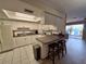 Bright kitchen featuring white cabinets, updated appliances, tile floors, and breakfast bar with seating at 5404 Springwood Blvd # 5404, Pinellas Park, FL 33782