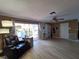 Cozy living room featuring wood floors, ceiling fan, a recliner chair, and sliding glass doors to the outside at 5404 Springwood Blvd # 5404, Pinellas Park, FL 33782