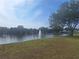 Calm pond with a central fountain, framed by green lawn and mature trees, adjacent to community amenities at 5404 Springwood Blvd # 5404, Pinellas Park, FL 33782