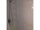 A clean shower area with a shower head, shelving, and a safety handrail at 5404 Springwood Blvd # 5404, Pinellas Park, FL 33782
