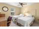 Bright bedroom with twin beds, desk, and ceiling fan at 5544 Caprice Way, Zephyrhills, FL 33541
