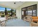 Enclosed porch area featuring large windows, sliding glass doors, and neutral colored indoor/outdoor furniture at 5544 Caprice Way, Zephyrhills, FL 33541