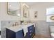 Stylish bathroom featuring dual sinks, marble accents, and modern gold fixtures and navy blue cabinets at 5724 Dr Martin Luther King Jr N St, St Petersburg, FL 33703
