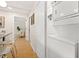Hallway with wood floors, laundry closet, and view into the living room with comfortable seating at 5724 Dr Martin Luther King Jr N St, St Petersburg, FL 33703