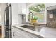 Bright kitchen sink with white cabinets, granite countertops, and a golden faucet set against a sunny window view at 5724 Dr Martin Luther King Jr N St, St Petersburg, FL 33703