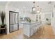 Modern kitchen with stainless steel appliances, island with seating, and pendant lighting at 5724 Dr Martin Luther King Jr N St, St Petersburg, FL 33703