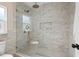 Elegant shower featuring marble tiling, glass enclosure, and rainfall shower head with elegant gold trim at 5724 Dr Martin Luther King Jr N St, St Petersburg, FL 33703