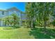Townhome featuring a well-maintained lawn and lush landscaping, providing a private outdoor space at 6782 Breezy Palm Dr, Riverview, FL 33578