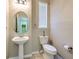 Modern half-bathroom features a pedestal sink, oval mirror, and neutral wall color at 6782 Breezy Palm Dr, Riverview, FL 33578