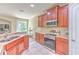 Modern kitchen with stainless steel appliances, granite countertops, wood cabinets, and a sink with a view at 6782 Breezy Palm Dr, Riverview, FL 33578